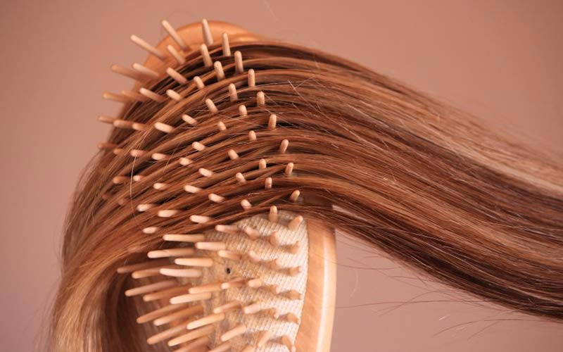 Mèche de cheveux avec brosse à cheveux en bois