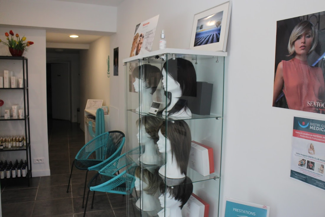Fauteuil de salon de coiffure noir placé face à un miroir avec des têtes de mannequins portant des perruques ou des turbans