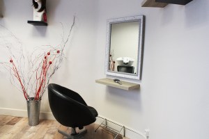 Fauteuil de salon de coiffure noir placé face à un miroir